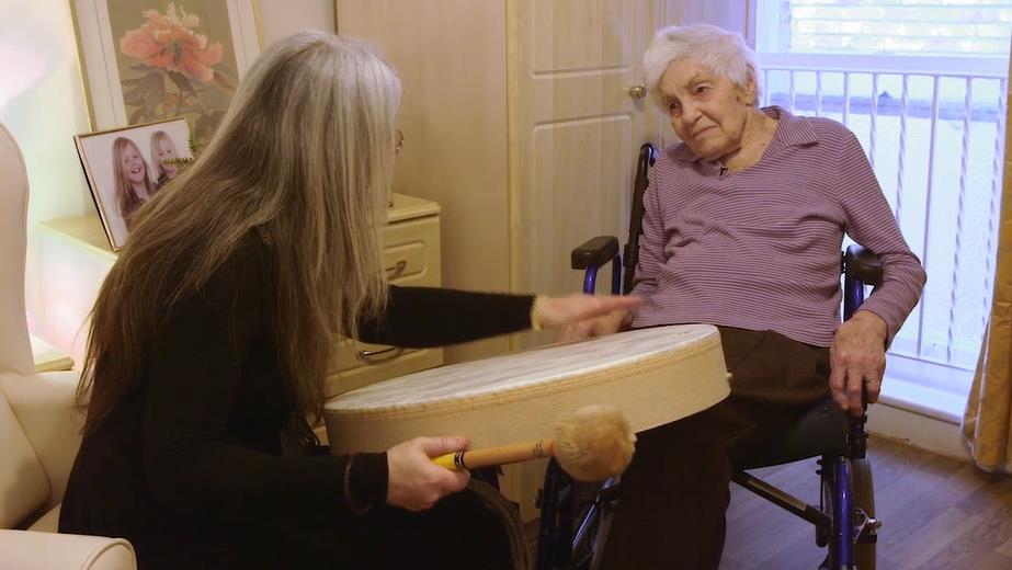 Evelyn alongside a dementia patient, using instruments to develop communication