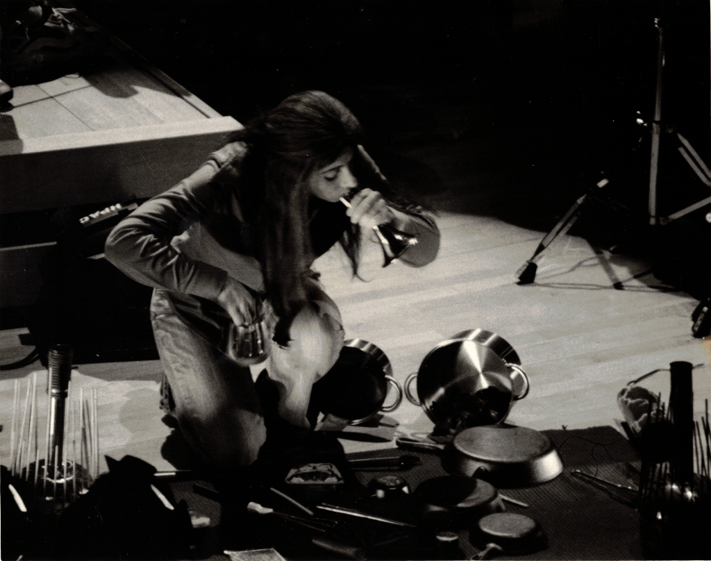 A black and white photo of Evelyn playing a selection of pans in 2007