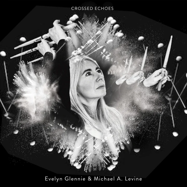 The striking black and white album cover for Crossed Echoes, by Evelyn Glennie and Michael A. Levine, featuring a photo of Evelyn as she holds aloft drumsticks, with a multi-layered effect giving a terrific sense of movement.